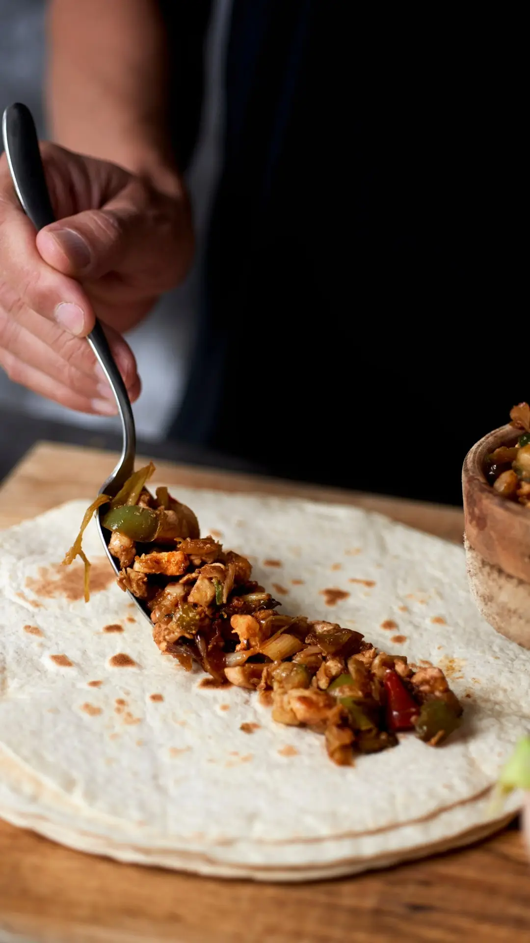 leckeres Fleisch wir auf Wrap mit Hilfe eines Löffels aufgetragen
